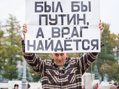 Активист Владимир Ионов с плакатом с надписью: "Был бы Путин, а враг найдется". Фото: Alexander Makarov / News-sirotin.com