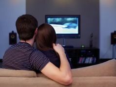 Девушка и молодой человек смотрят телевизор. Фото: Serg Zastavkin / Fotolia